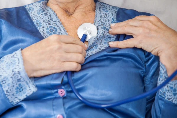 Старшая женщина исследует себя со стетоскопом — стоковое фото