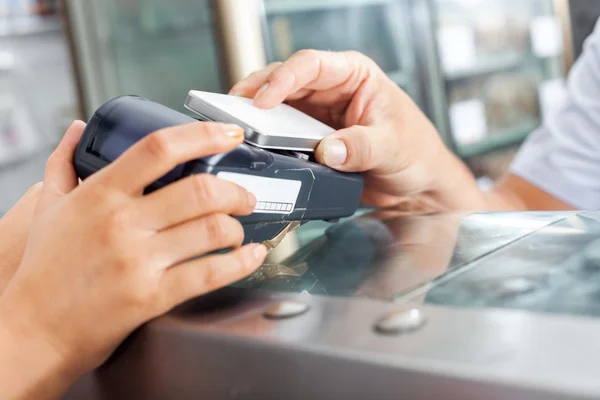 Cliente haciendo el pago a través de Smartphone en la carnicería — Foto de Stock