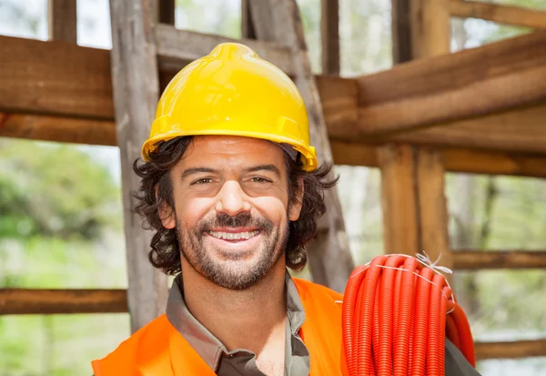 Ευτυχισμένος άνδρα εργαζόμενο με σωλήνα στο εργοτάξιο — Φωτογραφία Αρχείου