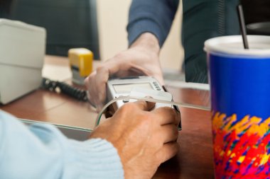 Sinema biletleri ödeme için NFC teknolojisi kullanan adam