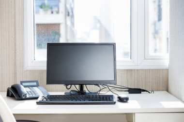 Bilgisayar ve sabit telefon üstünde okul sırası