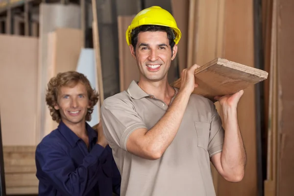 Carpenters Carrying Wooden Plank In Workshop — Stock Photo, Image