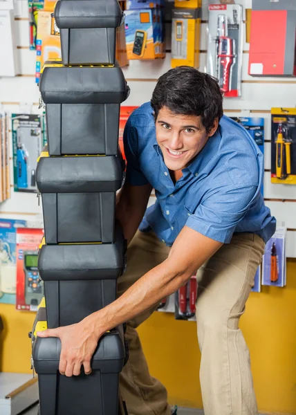 Homme portant des boîtes à outils empilées dans le magasin de quincaillerie — Photo