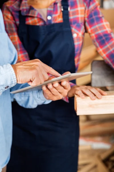 Timmerman met behulp van digitale Tablet tijdens het kijken naar collega — Stockfoto