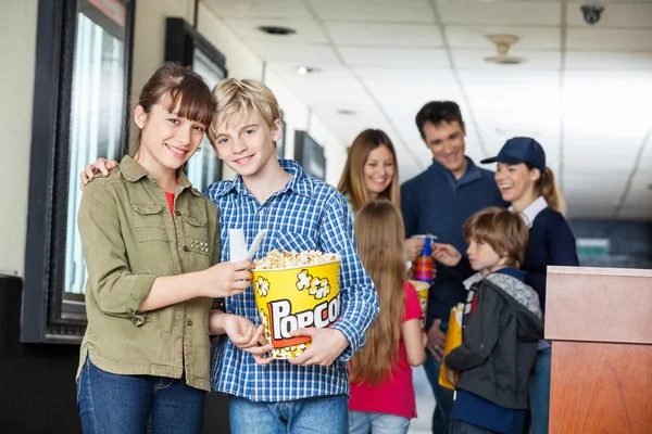 Feliz hermano y hermana sosteniendo palomitas de maíz en el cine —  Fotos de Stock