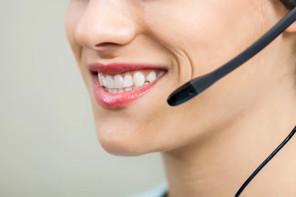 Sonriente agente de servicio al cliente femenino con auriculares —  Fotos de Stock