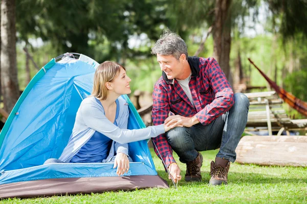 Paar hand in hand tijdens het opzetten van Tent In Park — Stockfoto