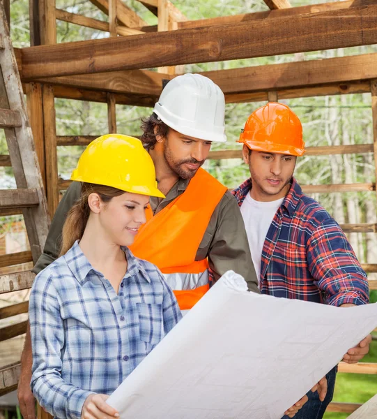 Ingegneri esaminando il progetto in cabina di legno — Foto Stock