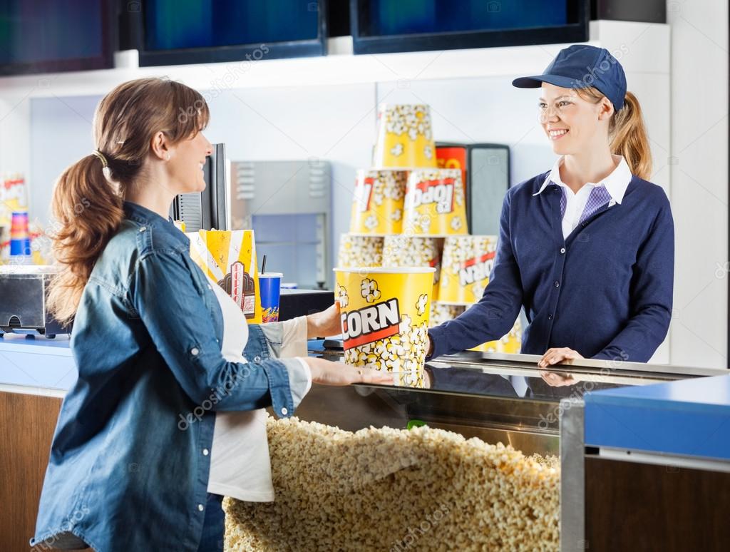 Pregnant Woman Buying Popcorn At Cinema Concession Stand