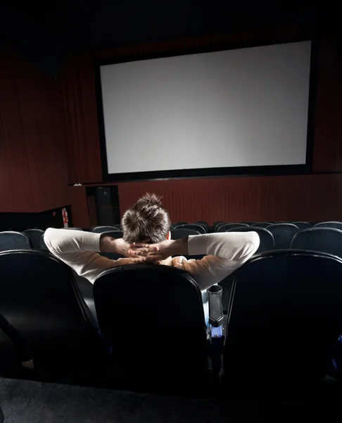 Uvolněné muž sledování filmu v kině — Stock fotografie