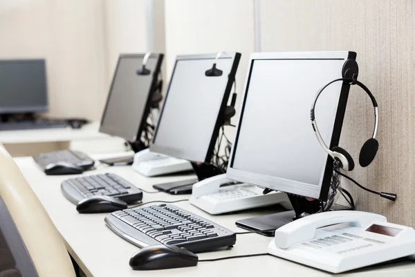 Computers met koptelefoon op Bureau — Stockfoto