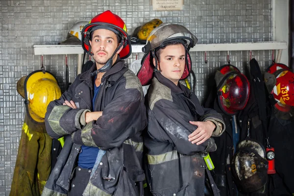 Bomberos confiados cruzados de brazos de pie — Foto de Stock