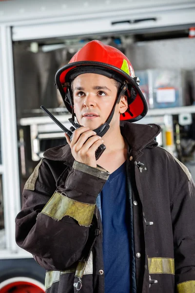 Mannelijke brandweerman met behulp van Walkie Talkie op brandweerkazerne — Stockfoto