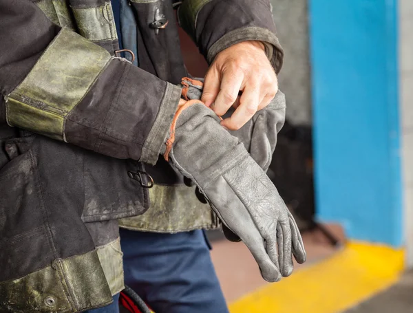 Firefighter Wearing Glove At Fire Station — Stock Photo, Image