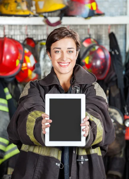 Firewoman visar Digital Tablet på brandstation — Stockfoto