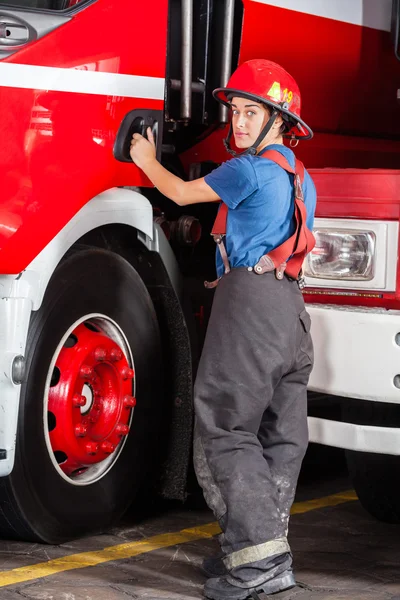 Retrato de bombeira confiante em pé junto ao caminhão de bombeiros — Fotografia de Stock