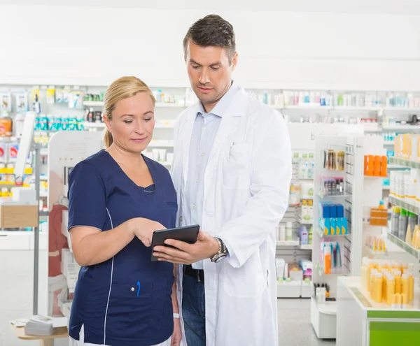 Assistente che utilizza il computer tablet con farmacista — Foto Stock