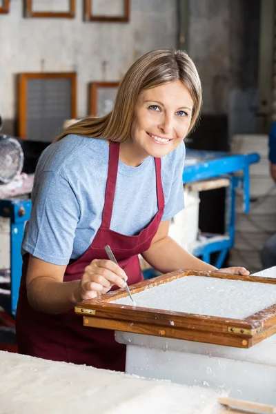 Vrouwelijke werknemer schoonmaken papier met een pincet — Stockfoto