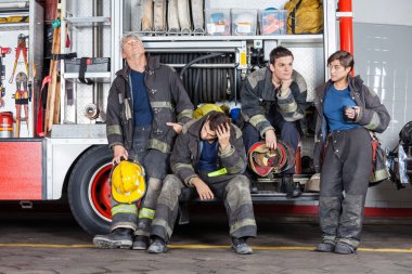 Team Of Tired Firefighters At Station clipart