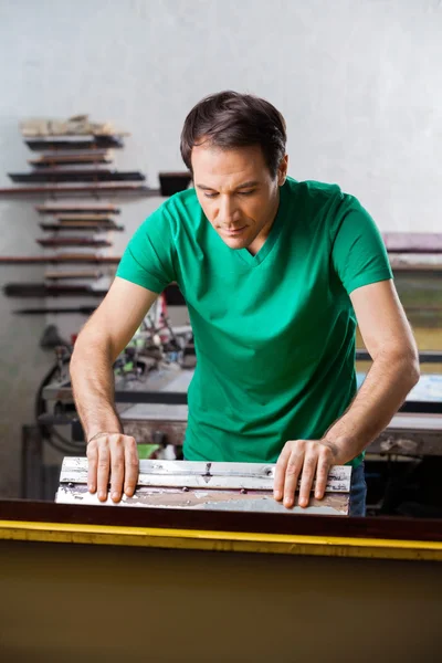 Hombre usando Squeegee en fábrica de papel — Foto de Stock