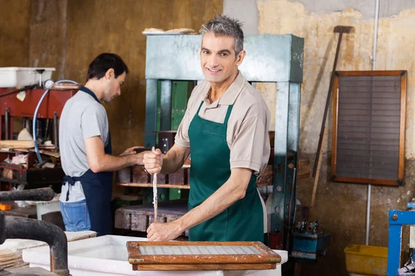 Polpa e acqua mescolanti del lavoratore sorridente con il bastone — Foto Stock