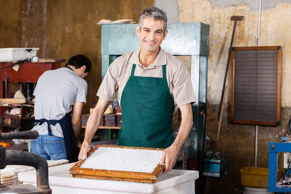 Trabalhador sorrindo Molde de mergulho na água polpa na fábrica de papel — Fotografia de Stock