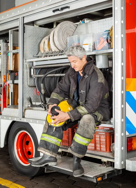 Pompier tenant tasse de café tout en étant assis dans le camion — Photo