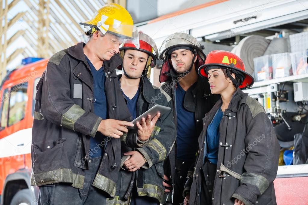 Team Of Firefighters Using Digital Tablet