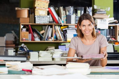Kendine güvenen kadın işçi fabrikada sarmal kitap tutan