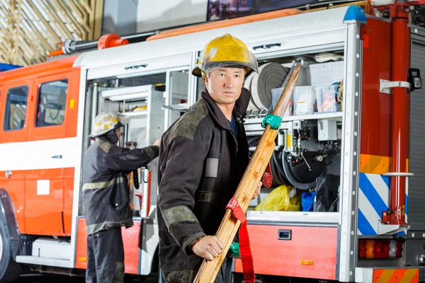 自信的消防员举着木制担架 — 图库照片
