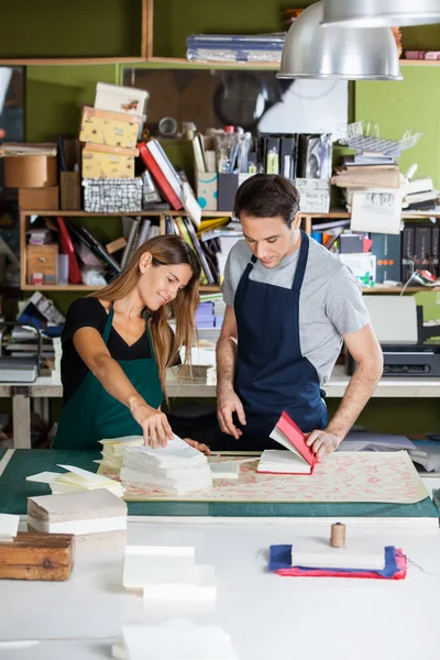 Lavoratori che fanno taccuino da documenti in fabbrica — Foto Stock