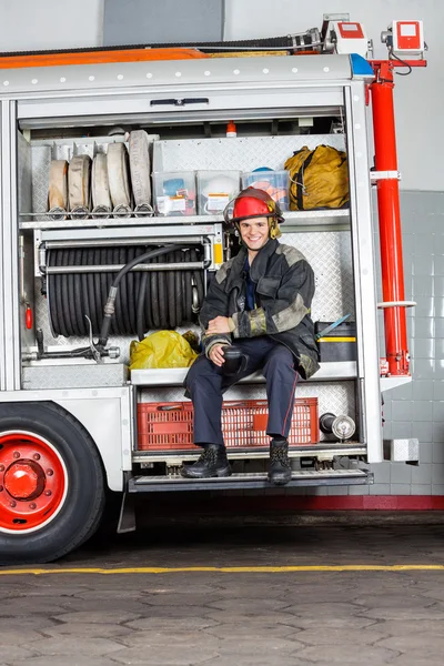 Glücklicher Feuerwehrmann mit Kaffeebecher im LKW — Stockfoto