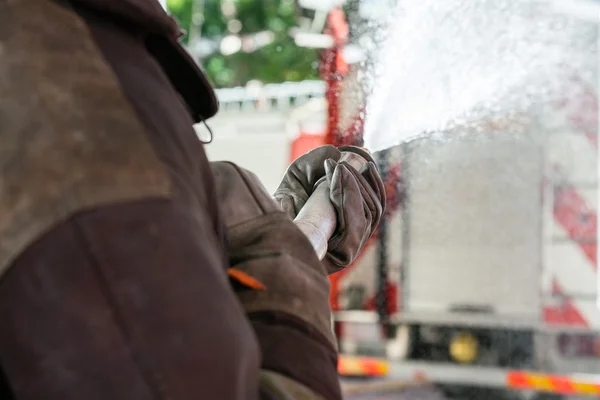 Bombero rociando agua durante la práctica — Foto de Stock