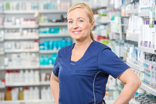 Femme souriante chimiste debout en pharmacie — Photo
