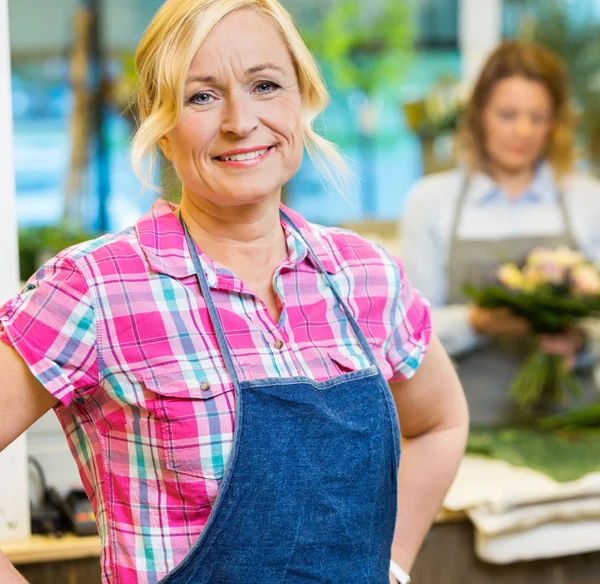 Retrato de una florista femenina sonriente en la tienda — Foto de Stock