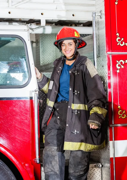 Glücklicher Feuerwehrmann in Uniform steht auf LKW — Stockfoto