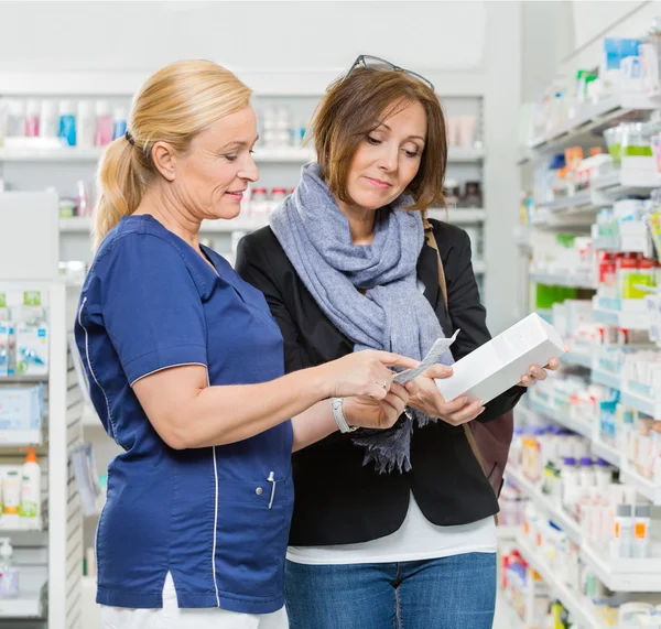 Mujer química explicando los detalles del producto al cliente — Foto de Stock