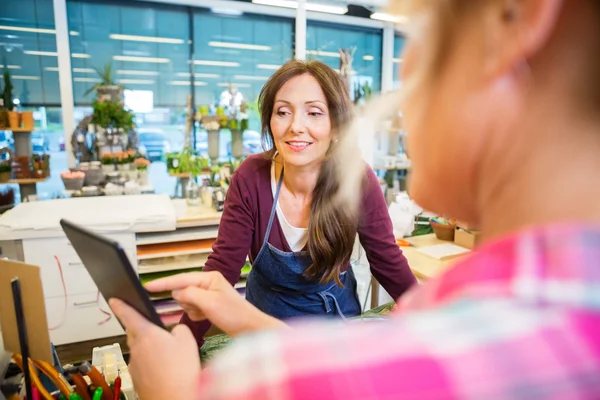 Látszó-on női ügyfél használ digitális tábla virágüzlet — Stock Fotó