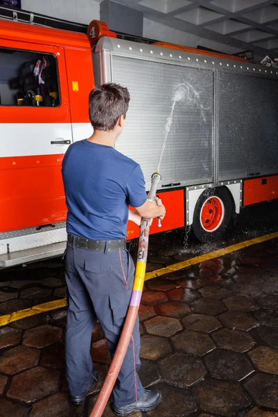 Brandweerman sproeien van Water op Truck tijdens de training — Stockfoto