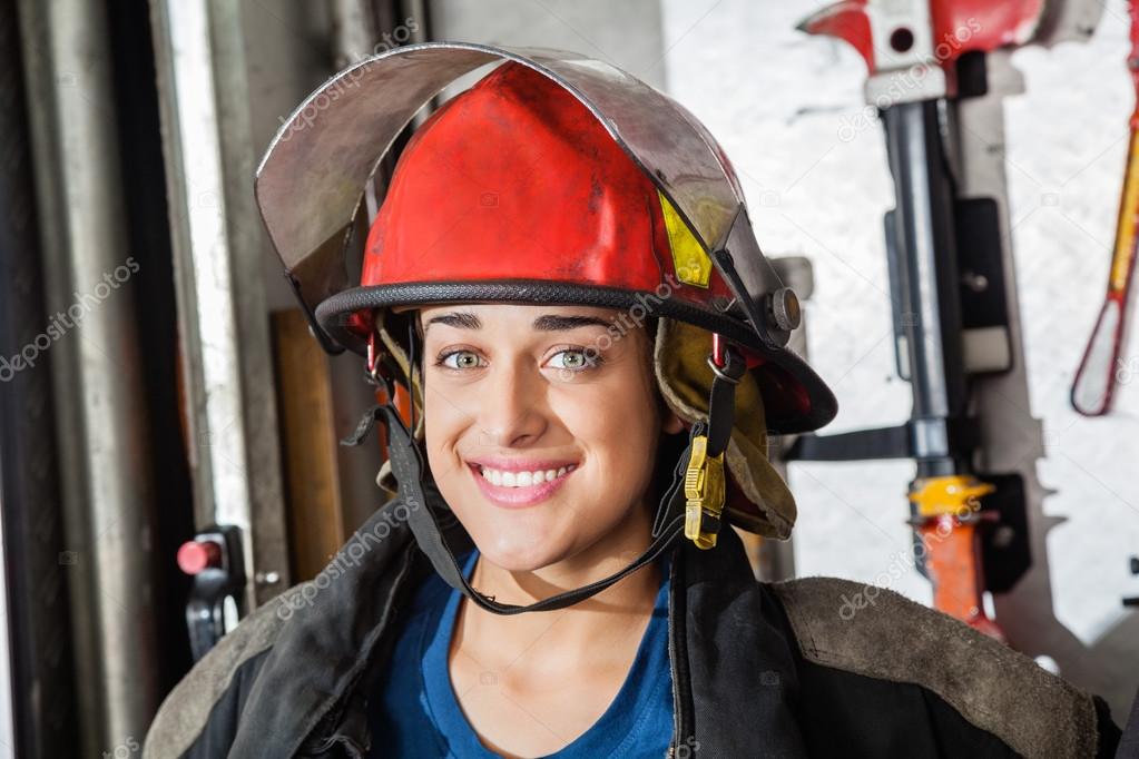 Happy Female Firefighter At Fire Station