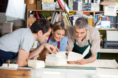 Workers Analyzing Papers Together In Factory clipart