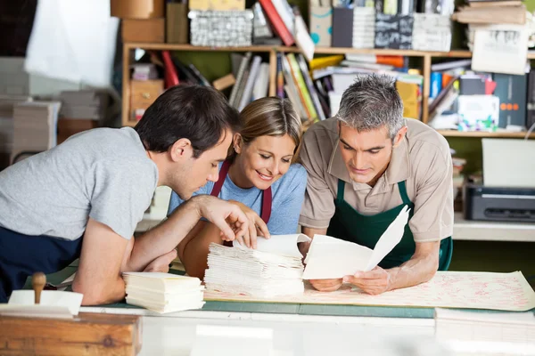 Arbeiter analysieren gemeinsam Papiere in Fabrik — Stockfoto