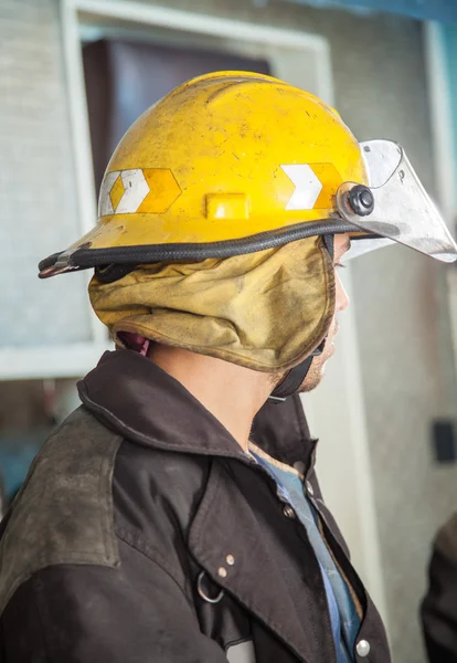 Hasič nosit žlutou helmu na požární stanici — Stock fotografie