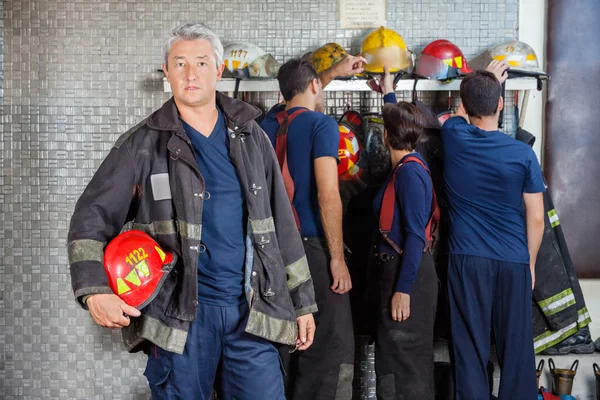 Jistý starší hasič stojící na požární stanici — Stock fotografie