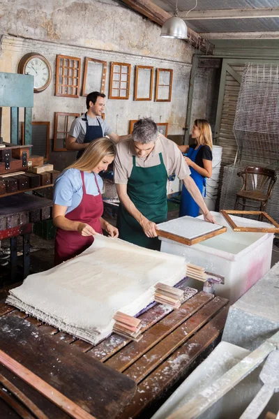 Workers Looking At Drying Papers In Factory — Stock Photo, Image