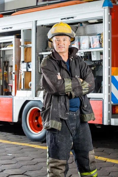 Selbstbewusster Feuerwehrmann steht gegen Lastwagen — Stockfoto