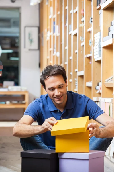 Cliente olhando para caixa de papelão amarelo na loja — Fotografia de Stock