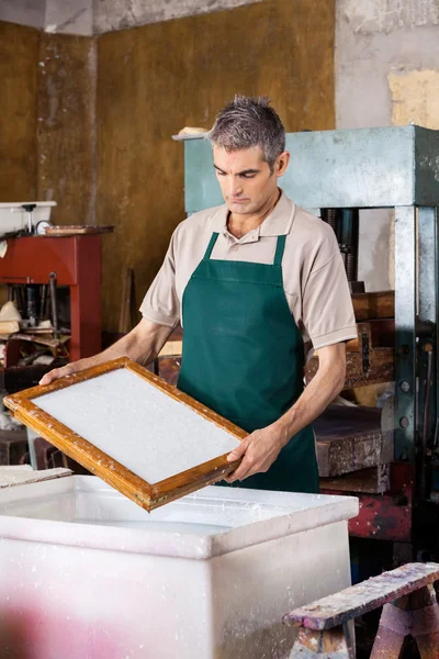 Arbeiter hält Schimmel über Zellstoff und Wassergemisch — Stockfoto