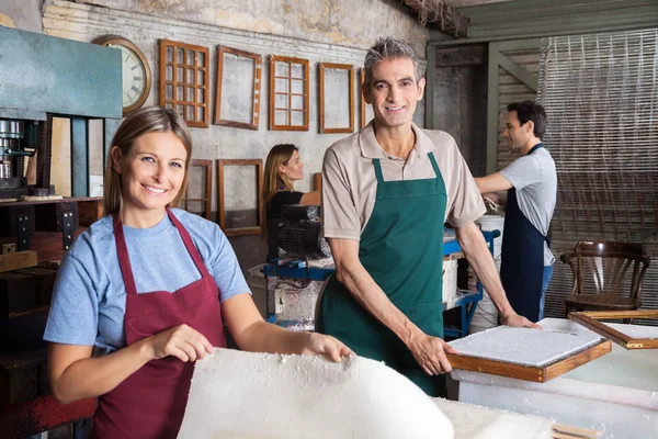 Trabalhadoras masculinas e femininas fazendo documentos na fábrica — Fotografia de Stock