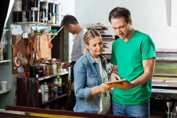 Handledaren visar digitala tablett till kollega i pappers-fabriken — Stockfoto